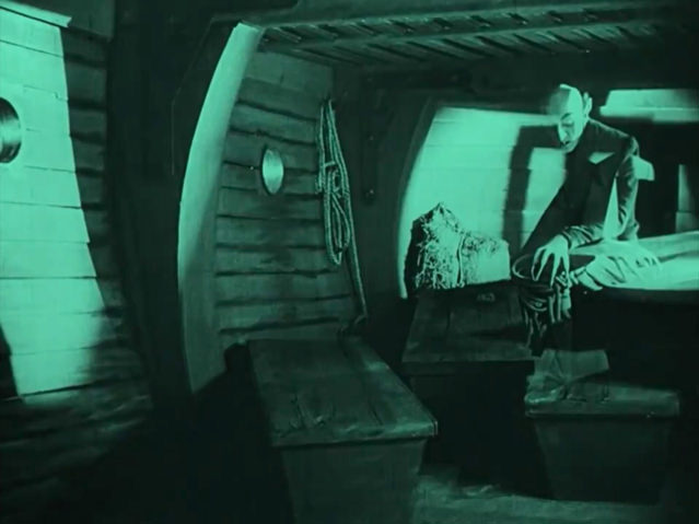 Dans la cale du navire, le spectre de Nosferatu semble flotter au-dessus des caisses en bois qu’il achemine vers sa nouvelle demeure de Wisborg…