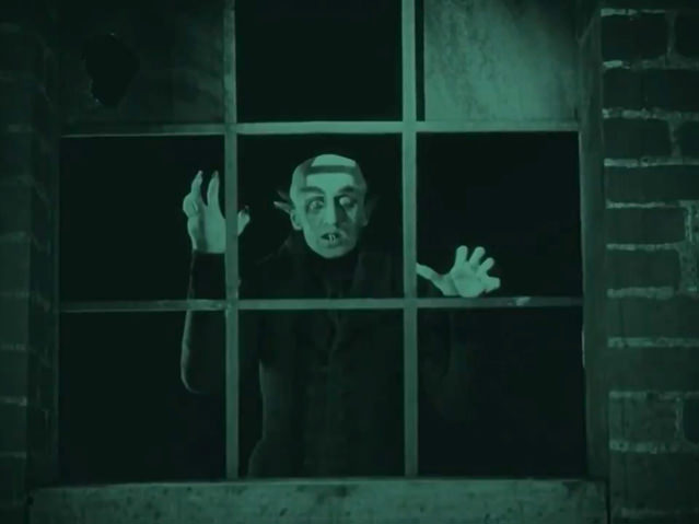 Ellen vient d’ouvrir sa fenêtre, invitant Nosferatu à entrer. Le comte Orlok, figé, s’anime lentement…